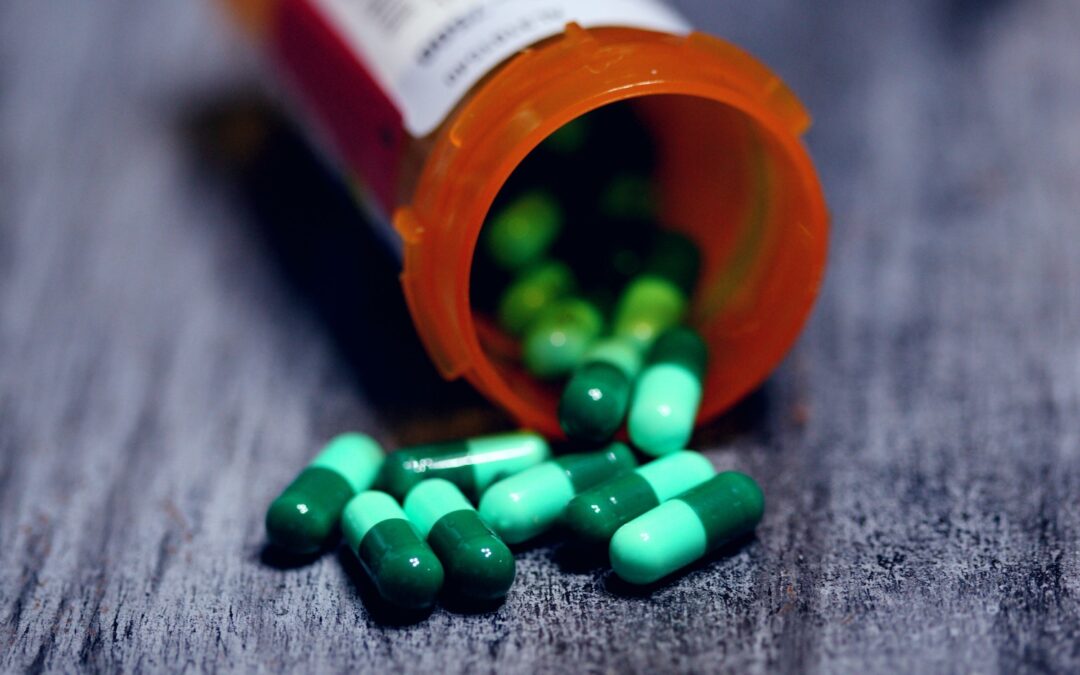 green pills in bottle and table
